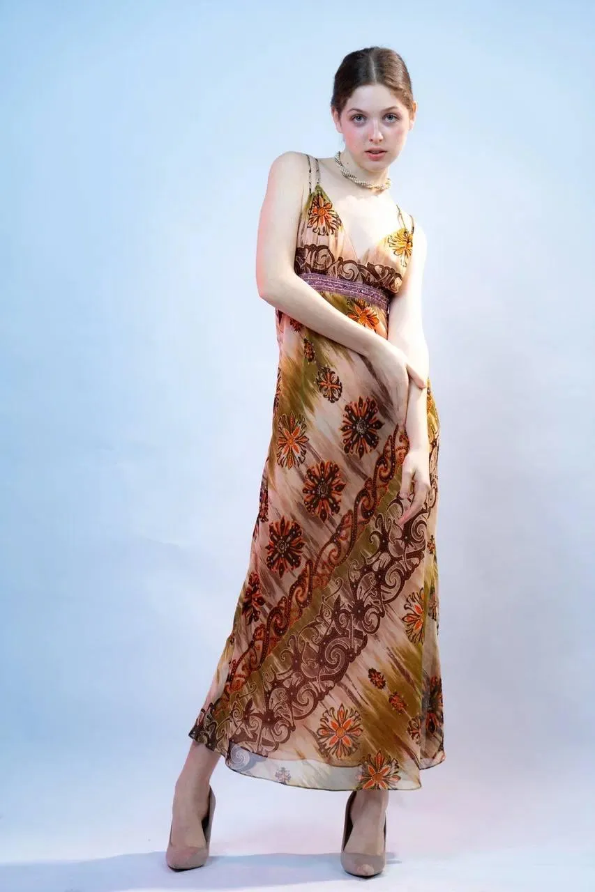 Woman in a floral dress posing against light blue background