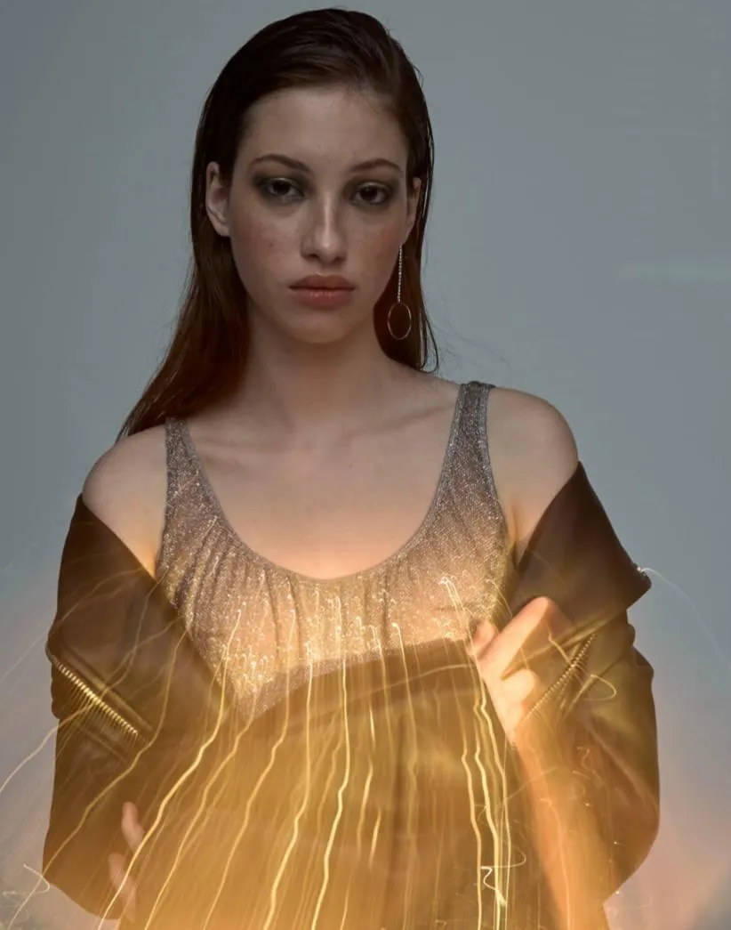 Woman in a glowing golden dress with artistic light effect