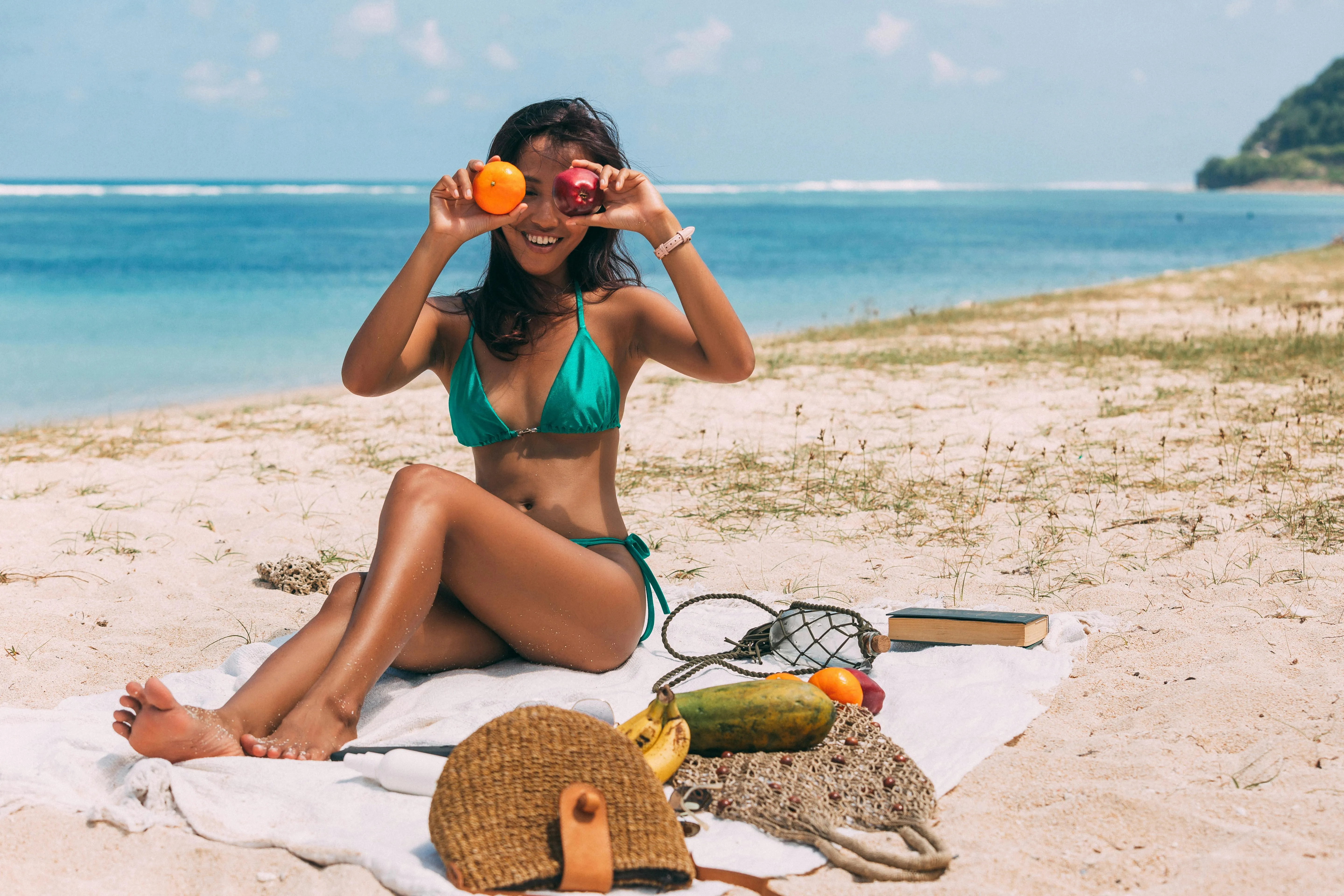 Woman in a Green Bikini While Sunbathing on a Peaceful Beach