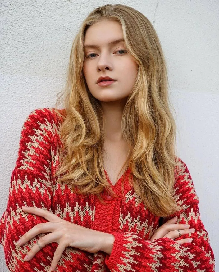 Woman in a Red Knit Top with Long Hair And a Gentle Smile