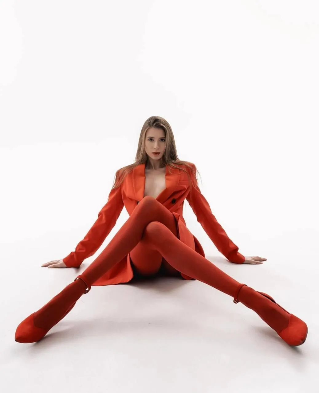 woman in a red outfit sitting on the floor with leg crossed