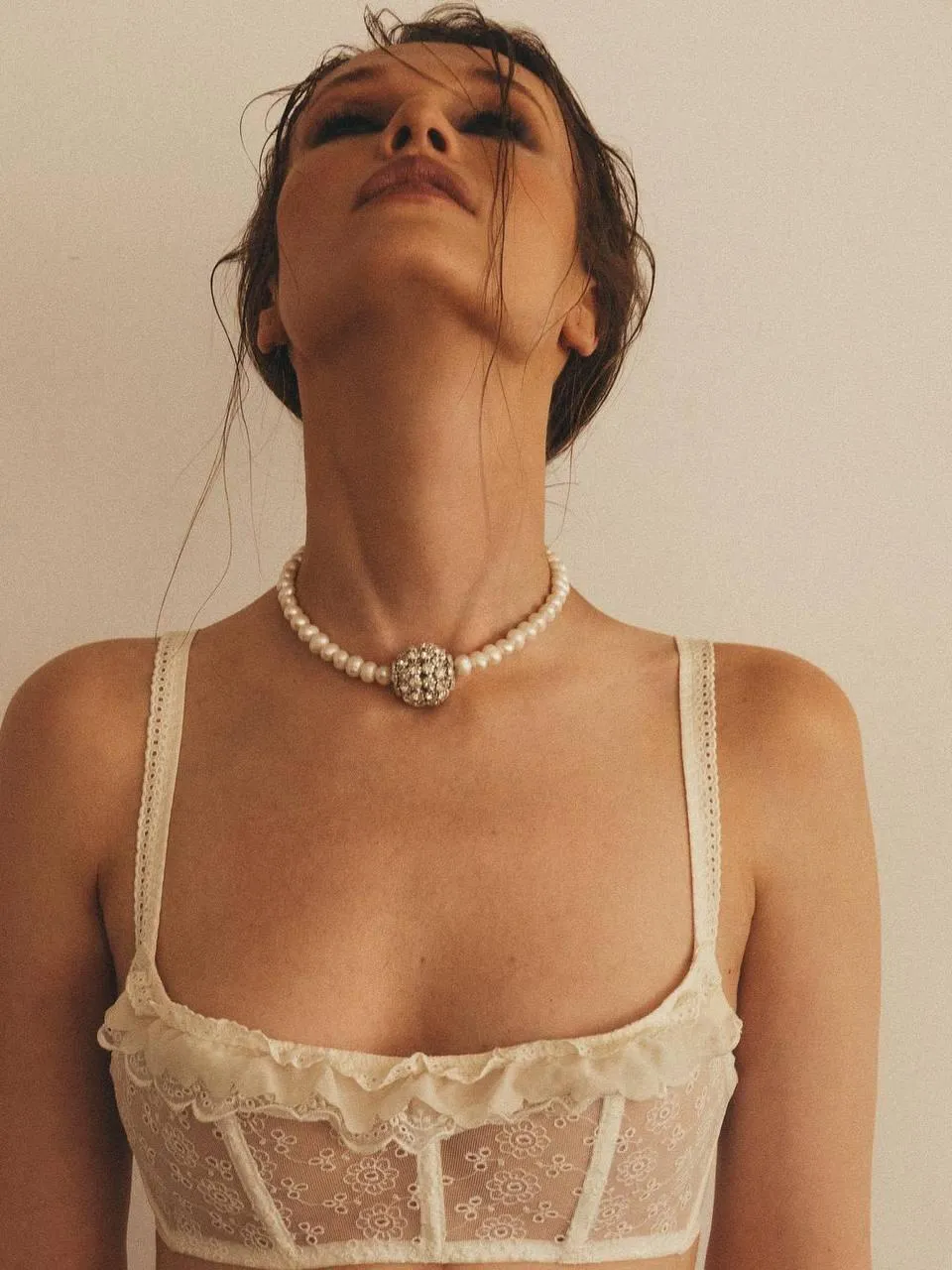 Woman in a Sheer White Top Posing with Head Tilted Wallpaper