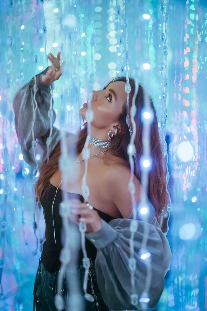 Woman in a Silver Outfit Glowing with Hanging Fairy Lights