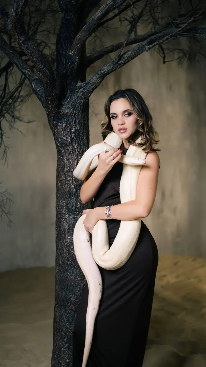 Woman in a strapless dress posing near a tree with a snake