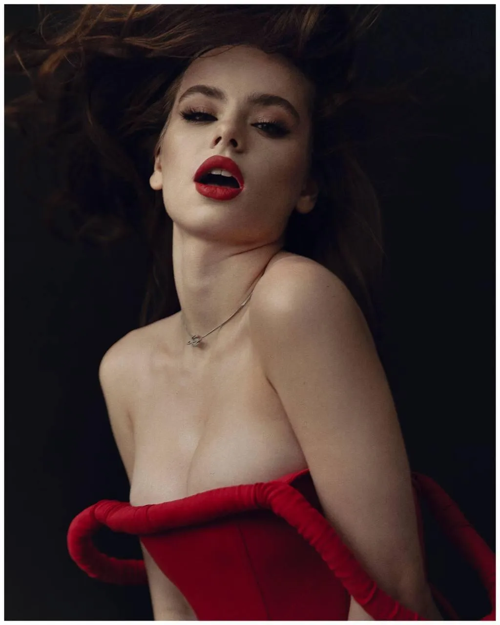 Woman in a strapless dress stares intently free Wallpaper