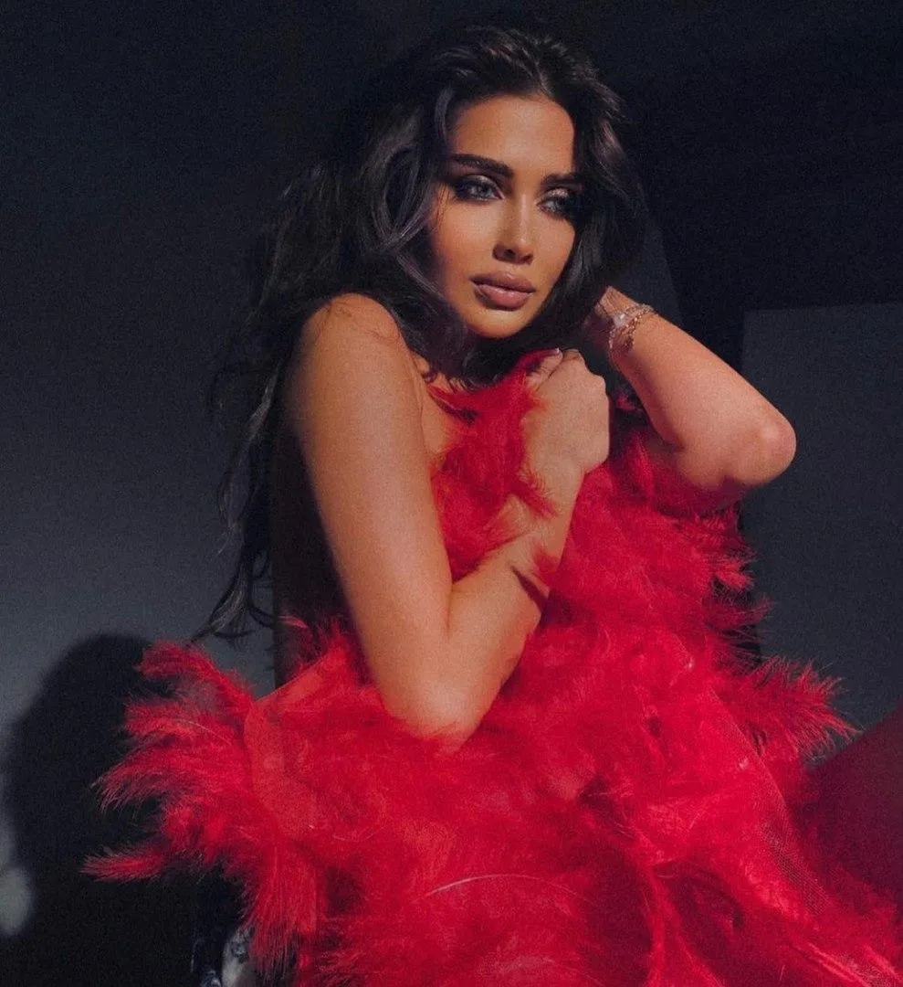 Woman in a Striking Red Dress Posing Dramatically Indoors