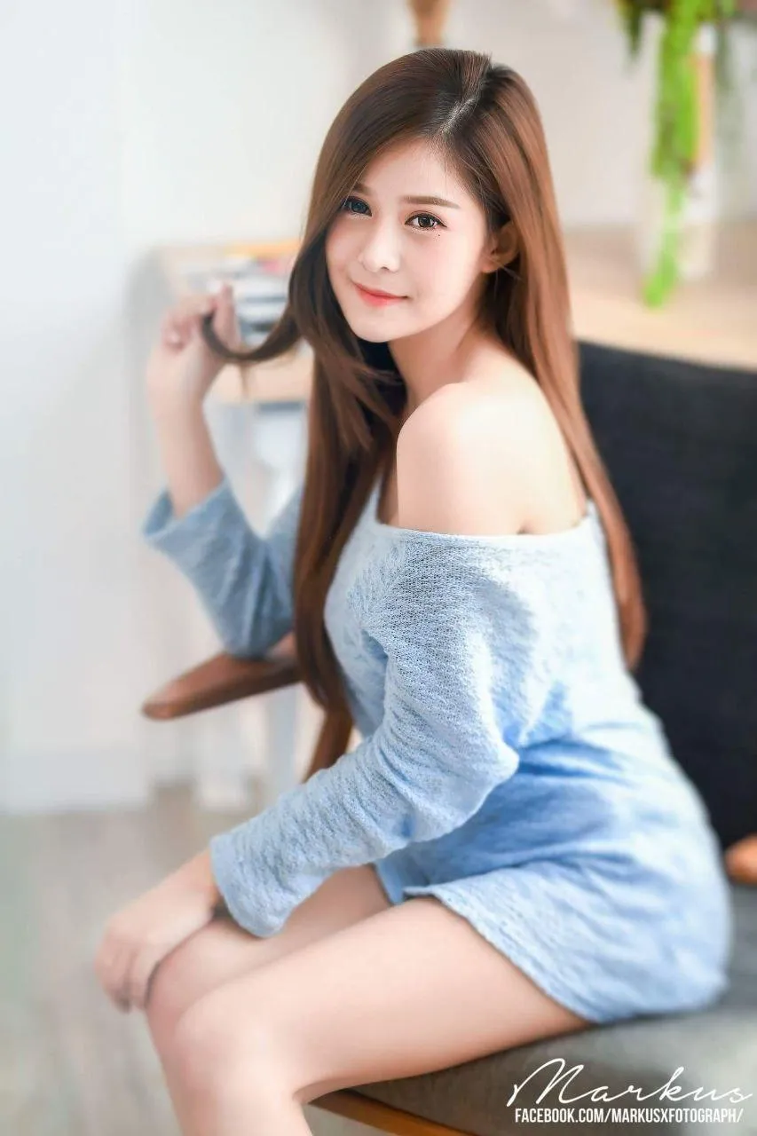 Woman in a sweater on a chair looking over her shoulder