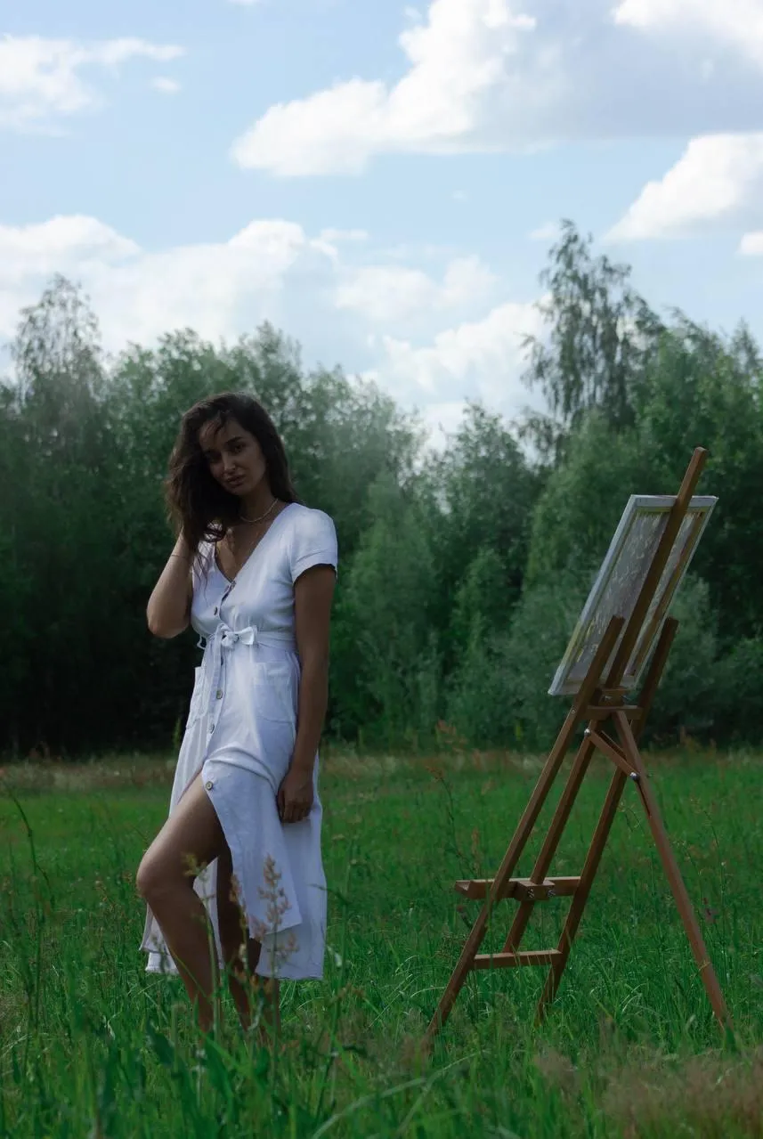 Woman in a White Robe Walking Barefoot in Green Grassy Field