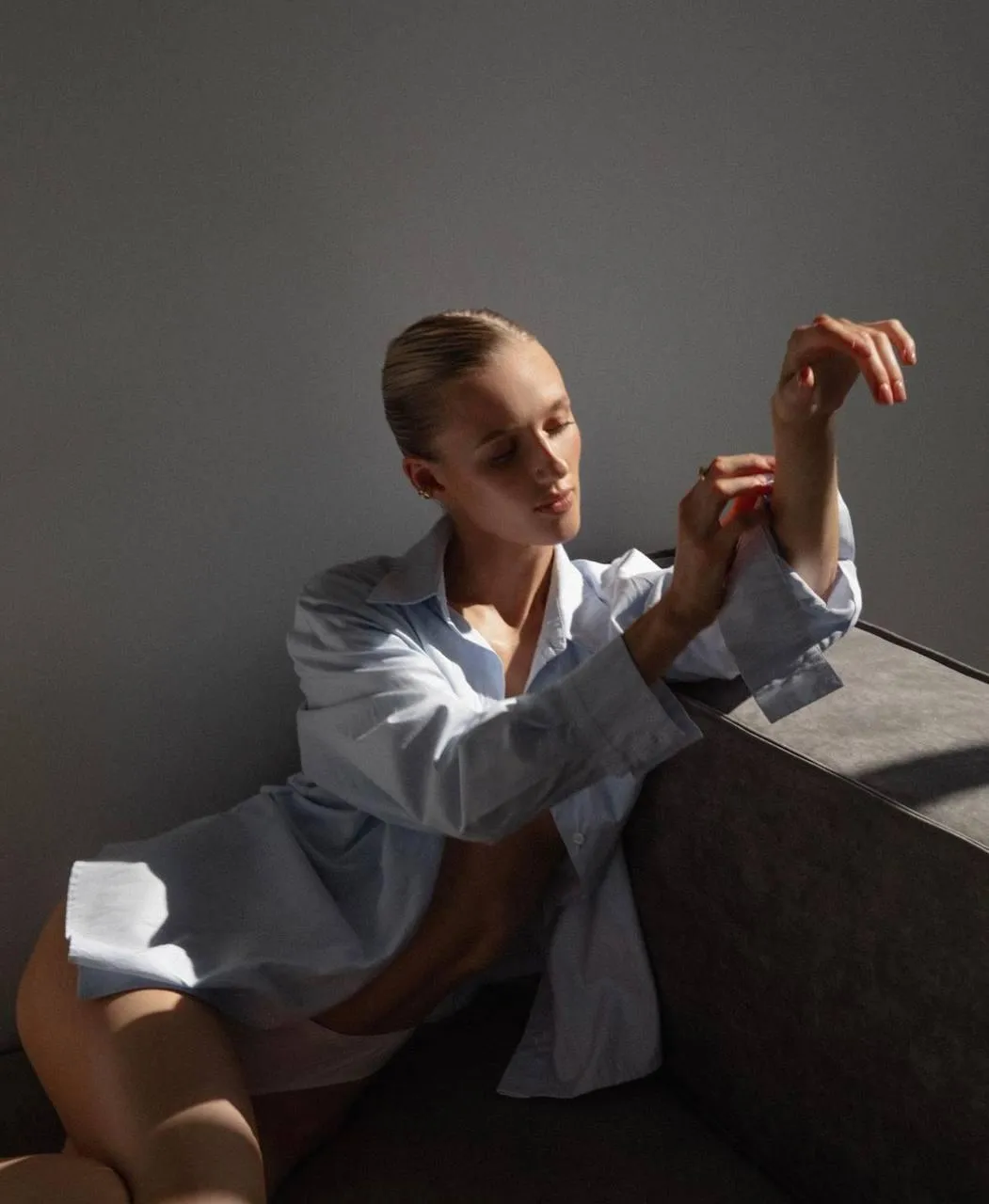 Woman in a White Shirt Sitting by Window with Natural Light