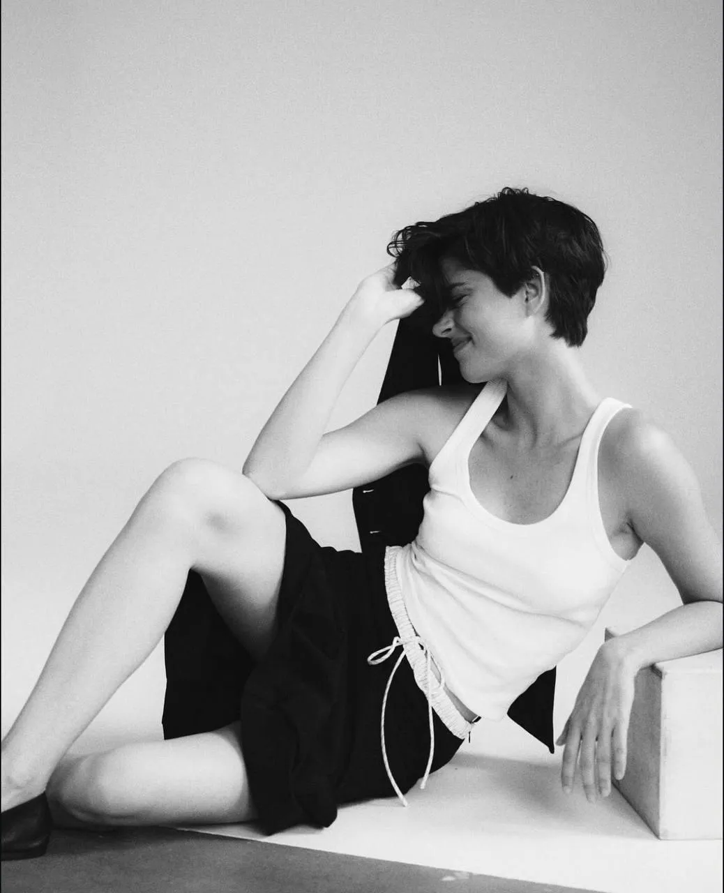 Woman in a White Tank Top And Shorts Sitting And Looking Up