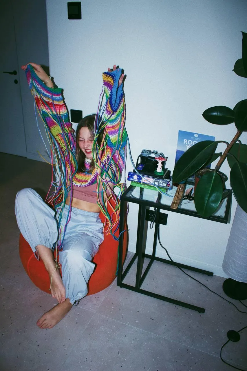 Woman in Colorful Jacket Sitting on Chair in Casual Setting