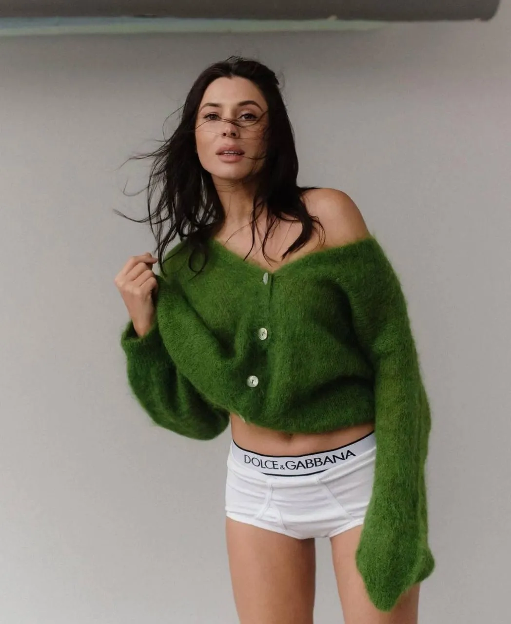 Woman in Green Sweater And White Skirt Standing Confidently