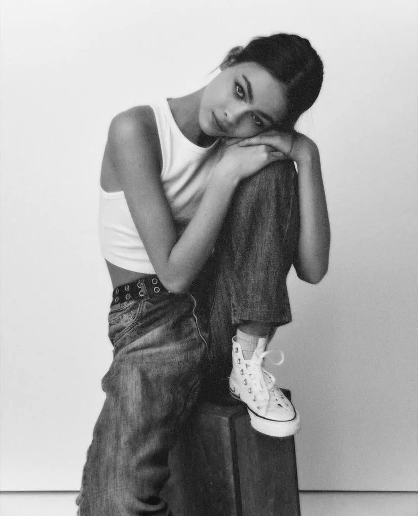 Woman in jeans and head on her knee in black and white image
