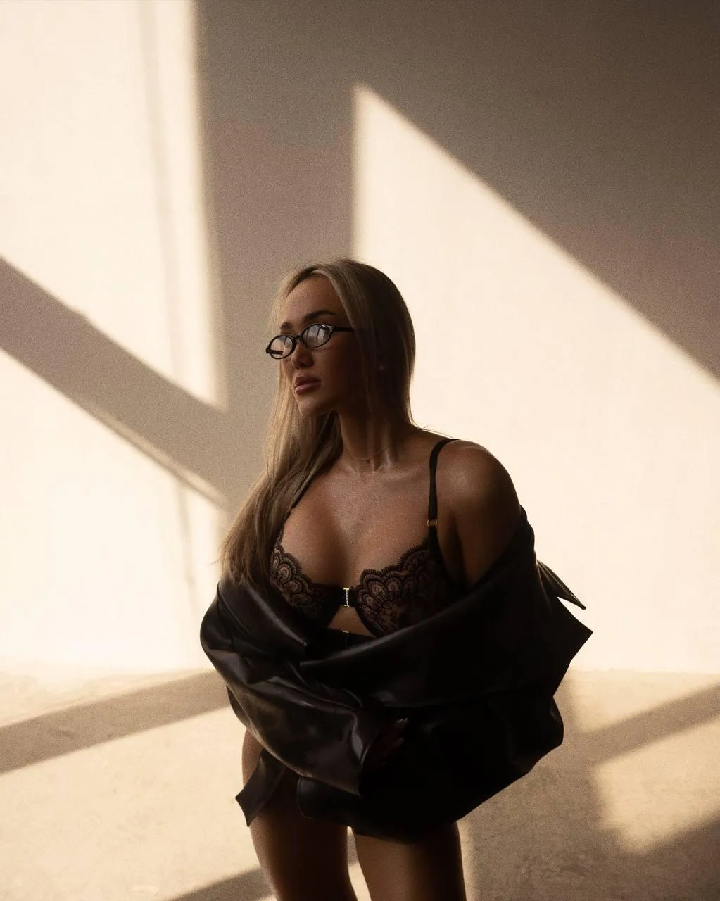 Woman in Off Shoulder Dress Lit by Dramatic Window Lighting