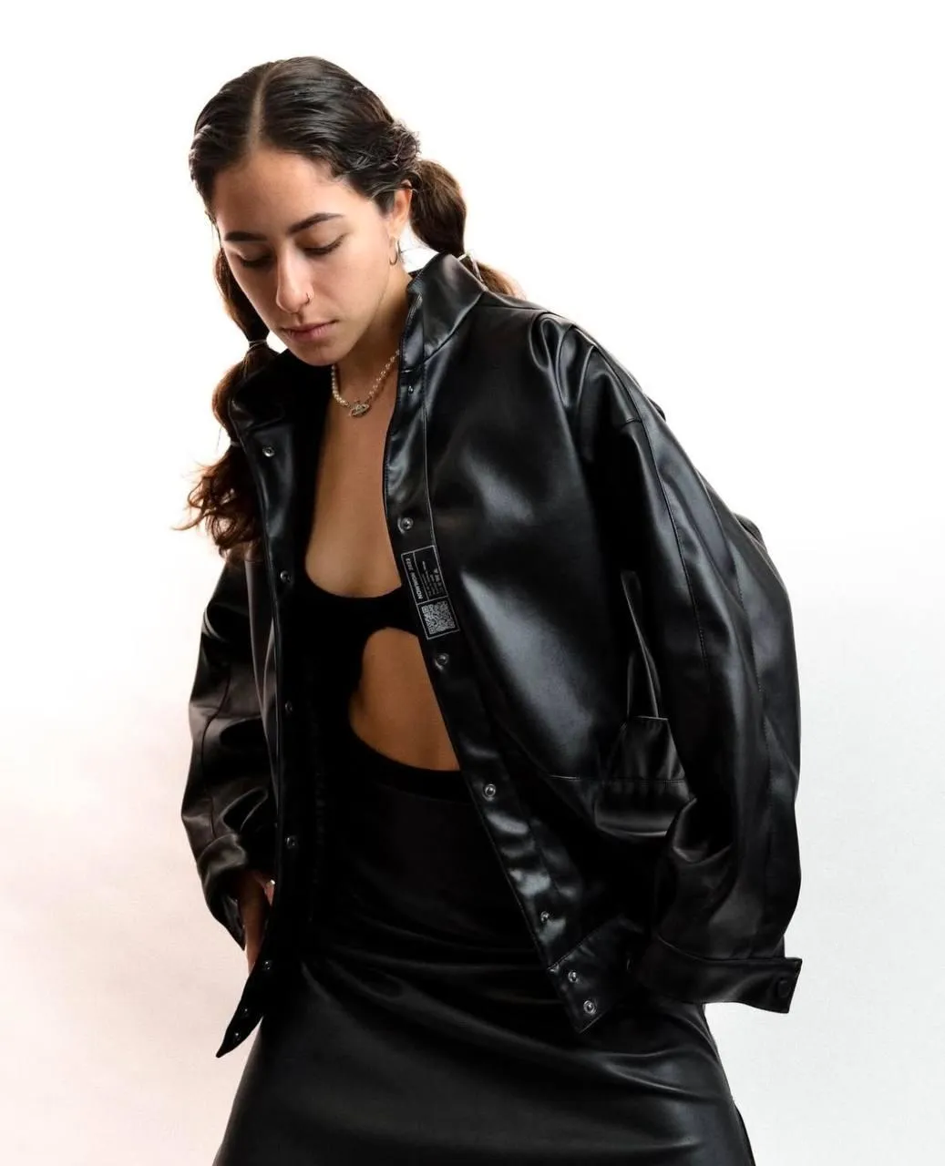 Woman in oversized black jacket posing with a confident look