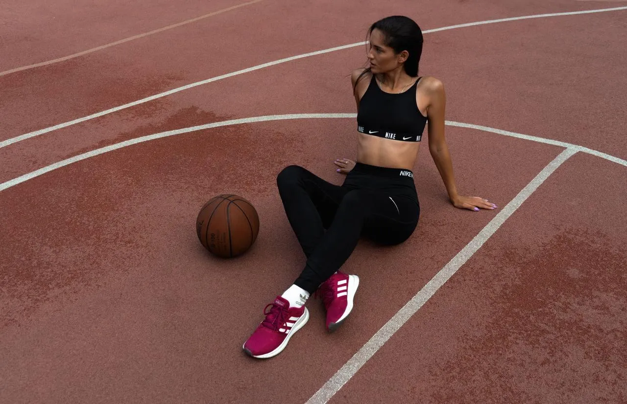 Woman in Sportswear Resting on an Outdoor Basketball Court