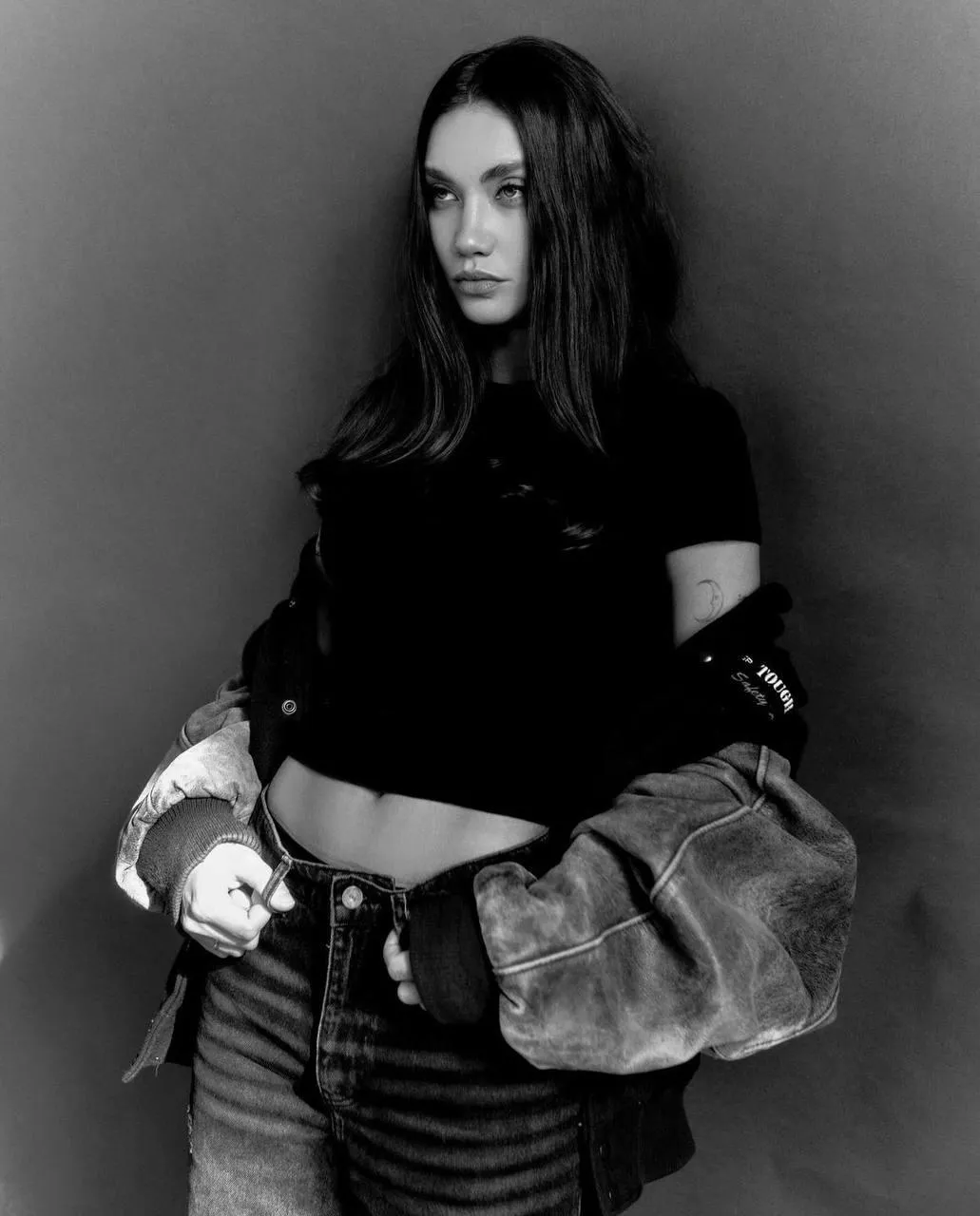 Woman in Sweater Posing Confidently in a Moody Black Outfit