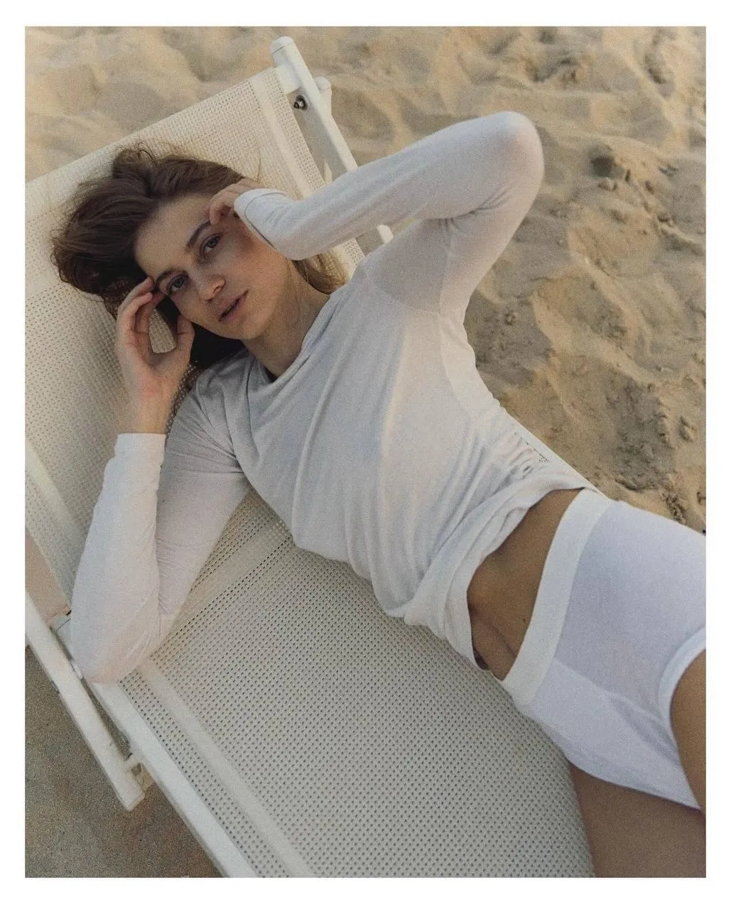 Woman in White Lounge Set Reclines on Beach Chair at Sunset