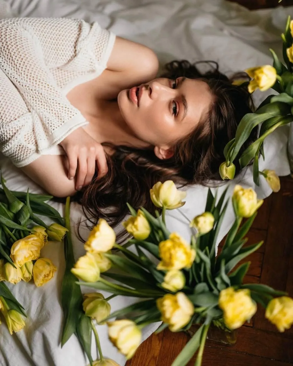 Woman Lying Among Yellow Tulips with Soft Sunlight Around
