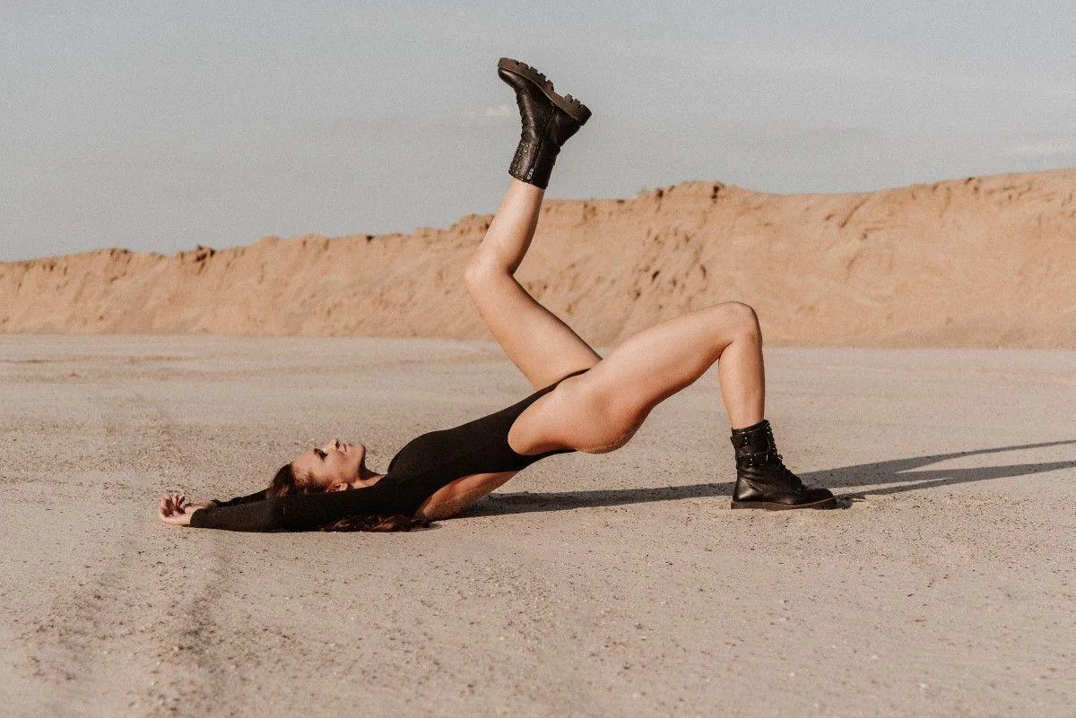 Woman Lying in the Desert with Legs Up And Playful Energy