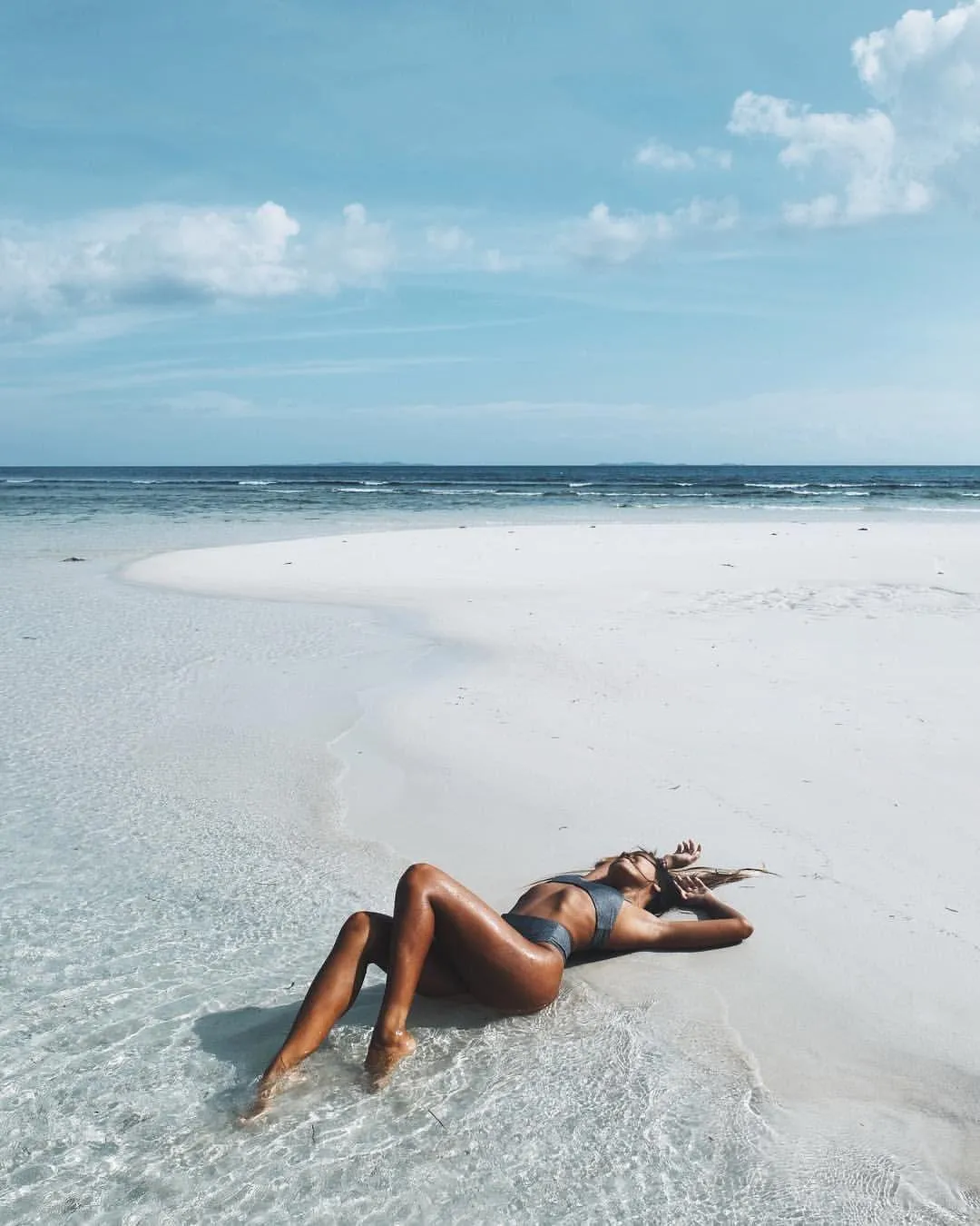 Woman Lying on a Tropical White Beach with a Blue Sky View