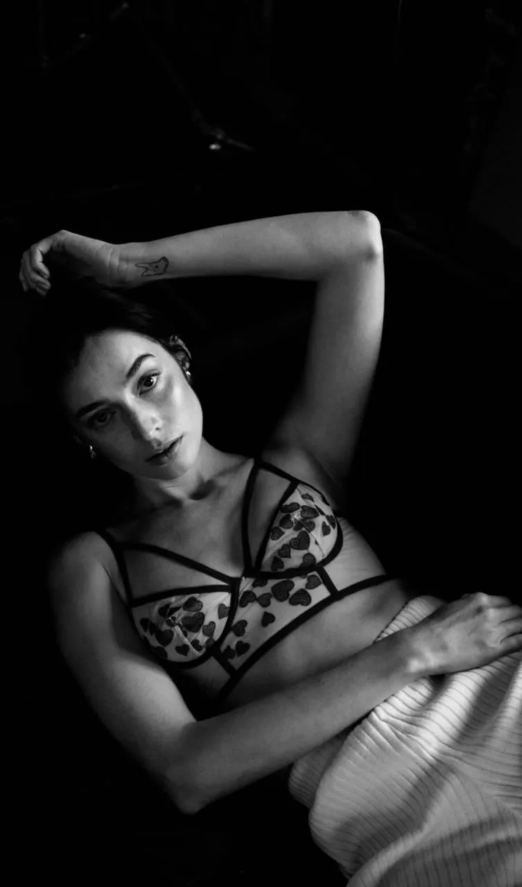 Woman lying on the bed with her left hand on her head image