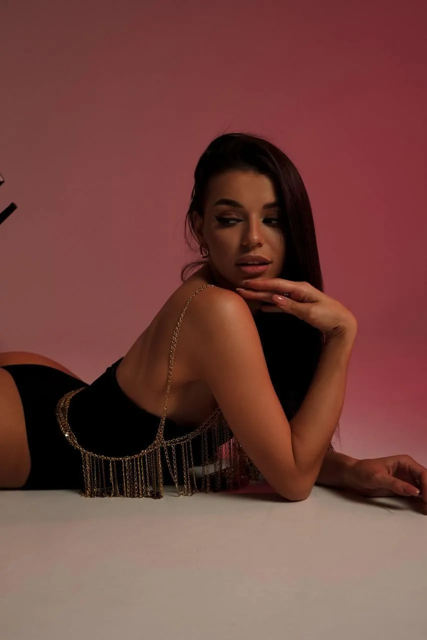 woman lying on the studio floor while wearing a black dress