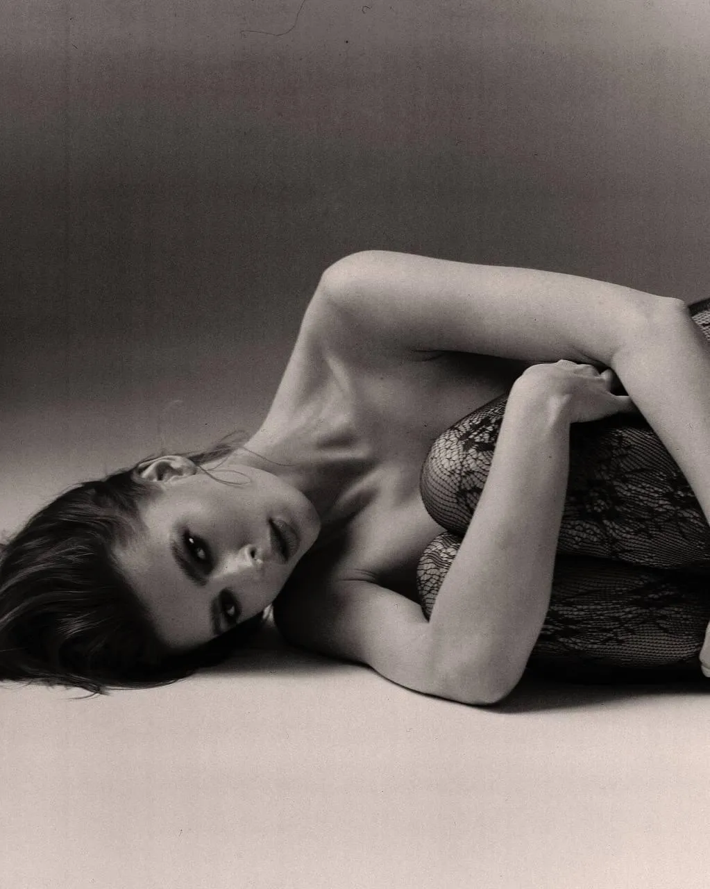 Woman Lying Sideways on the Floor in a Relaxed Black Outfit