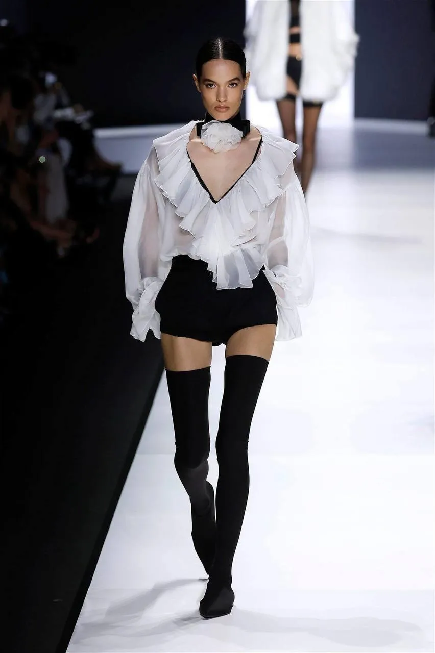 Woman model walking on a runway wearing a fashionable outfit