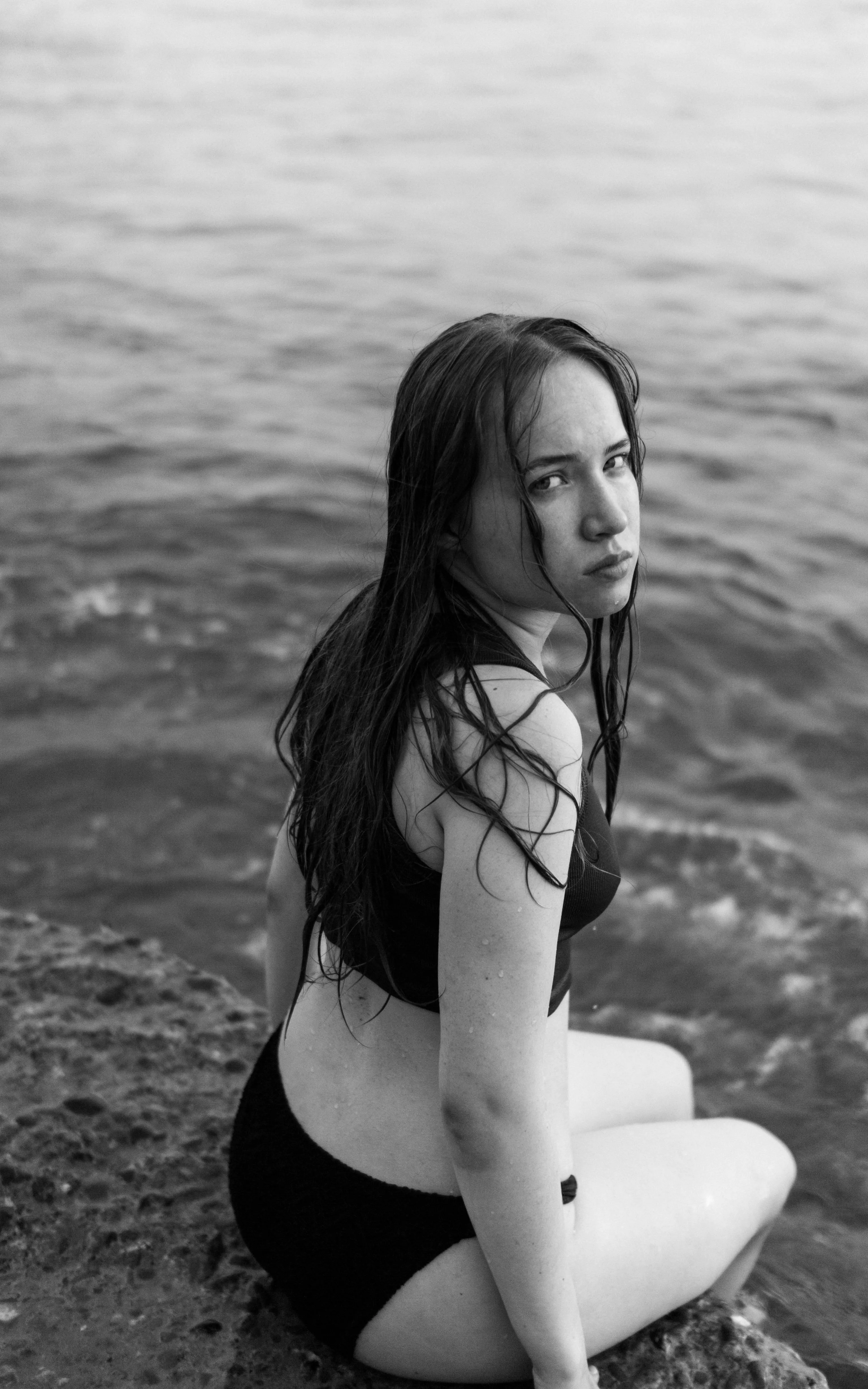 Woman Near Water Looking Back with Wind in Her Hair Image