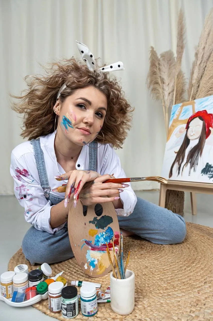 Woman Painting at Home Wearing a White Shirt And Blue Jeans