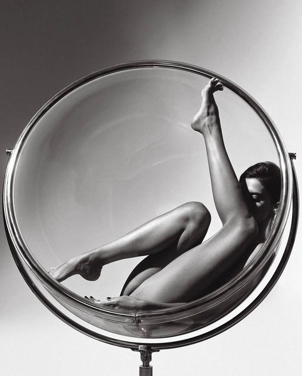 Woman Posing Inside a Clear Circular Chair in Dramatic Style