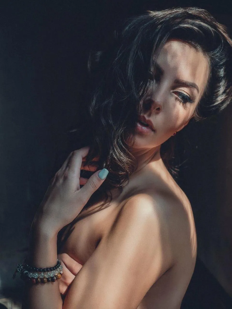 Woman Posing Sensually in Low Light with Bare Shoulder Image