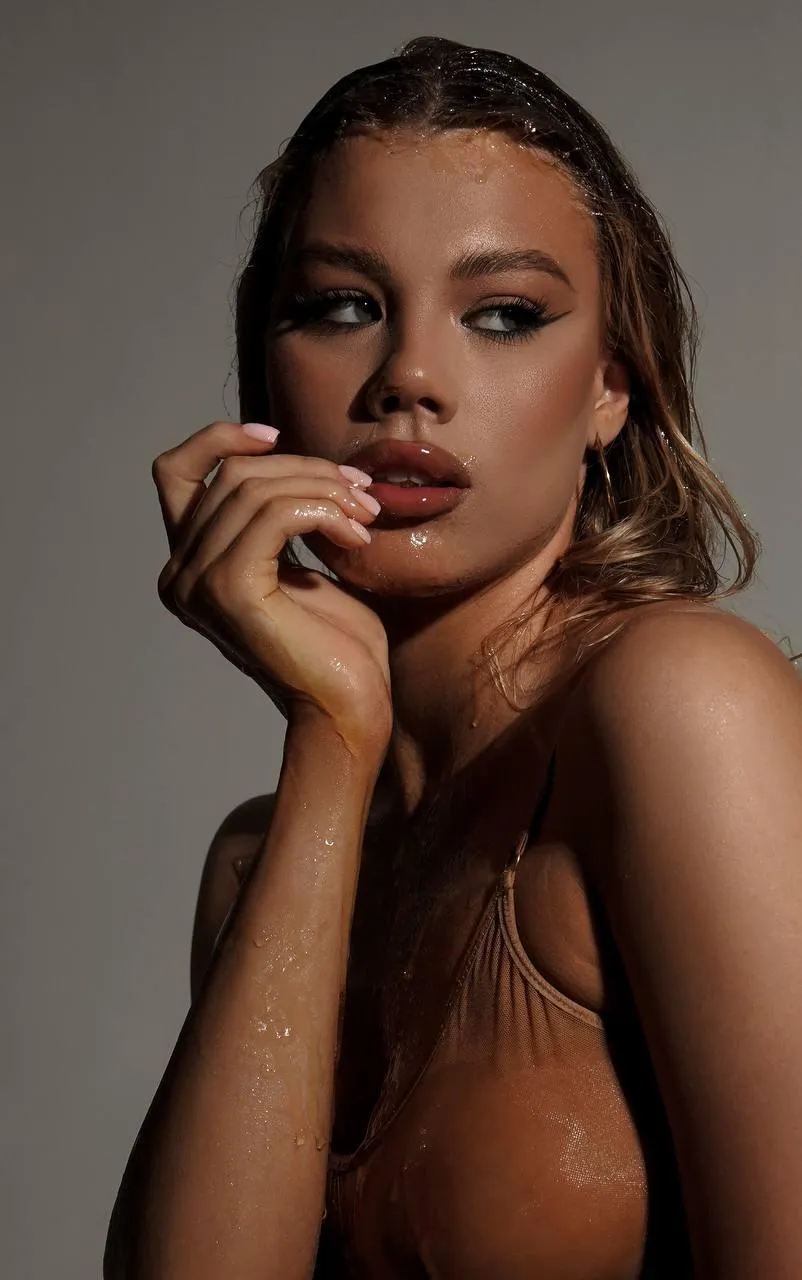 Woman posing with hand on chin in a warm lighting portrait