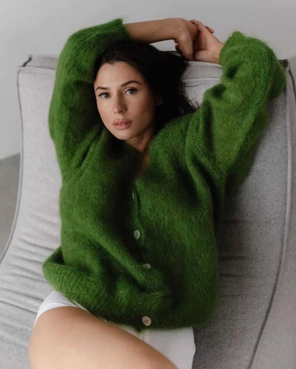 Woman Reclining on Sofa in Cozy Green Sweater Relaxed Image