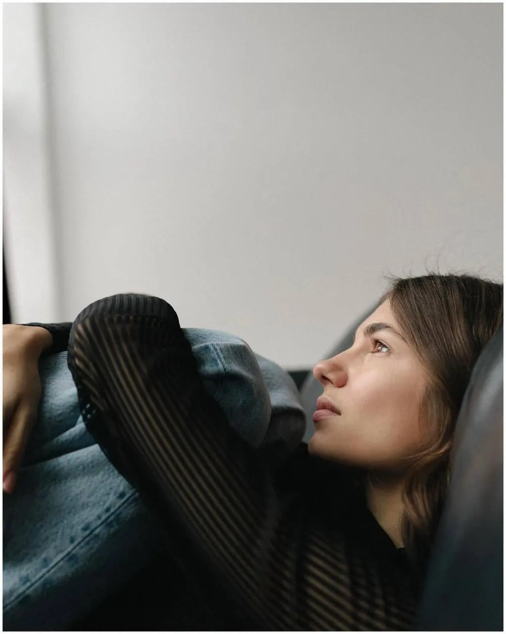 Woman resting her head on her arm in an indoor setting image