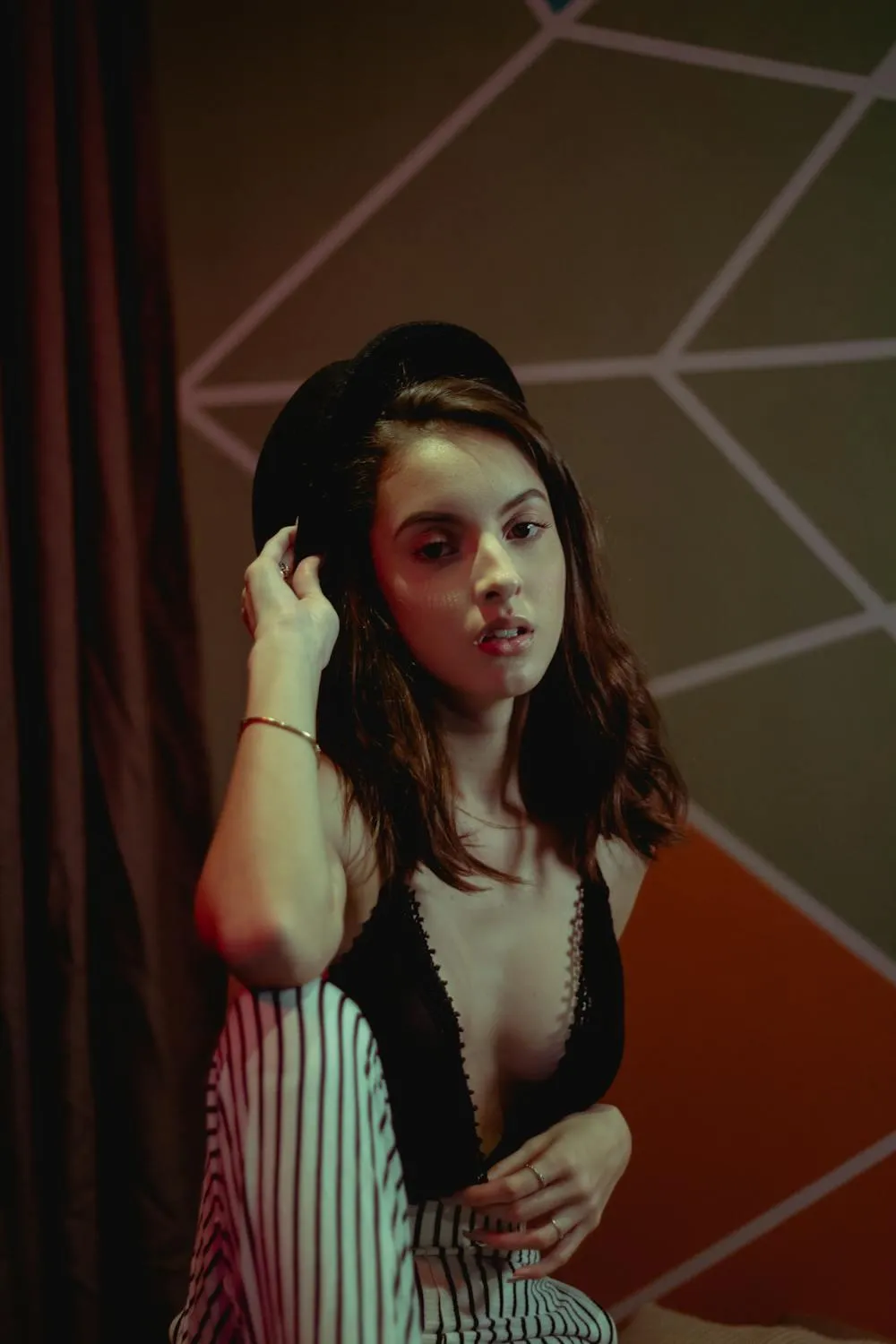 Woman sitting indoors with striped pants and a black top