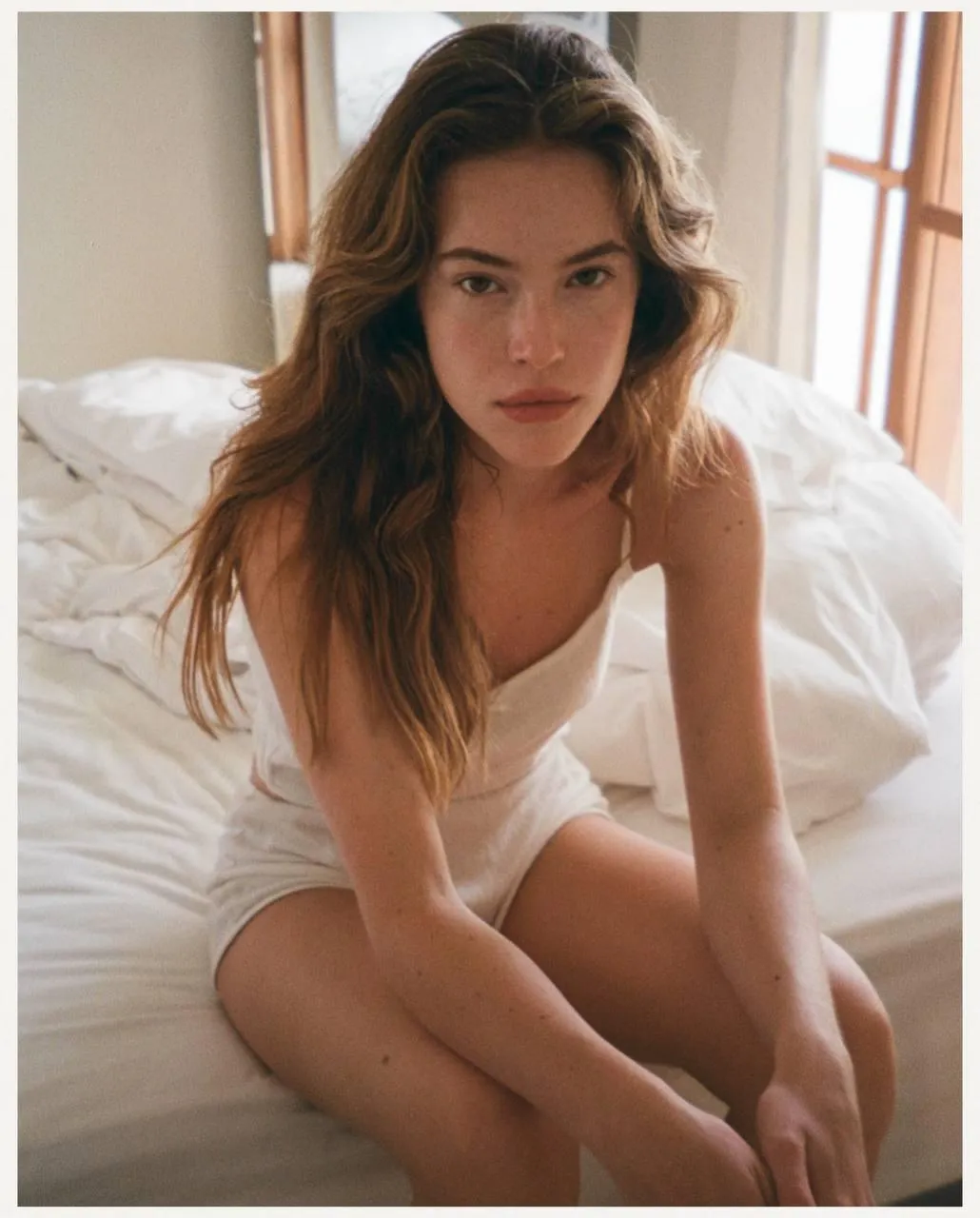 Woman Sitting on a Bed in a Soft Morning Light Atmosphere