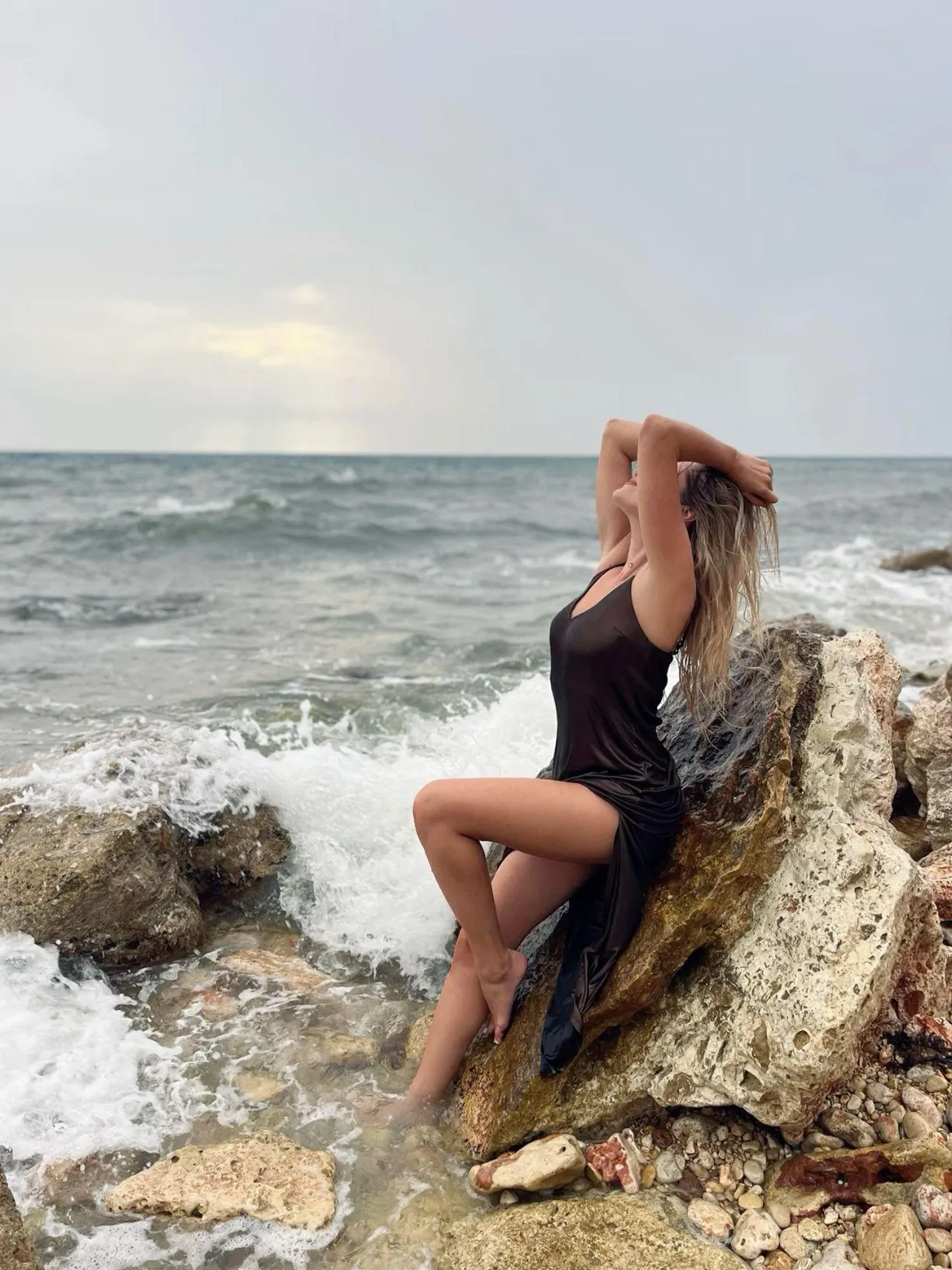 Woman Sitting on a Rock by the Ocean Shore Free Wallpaper