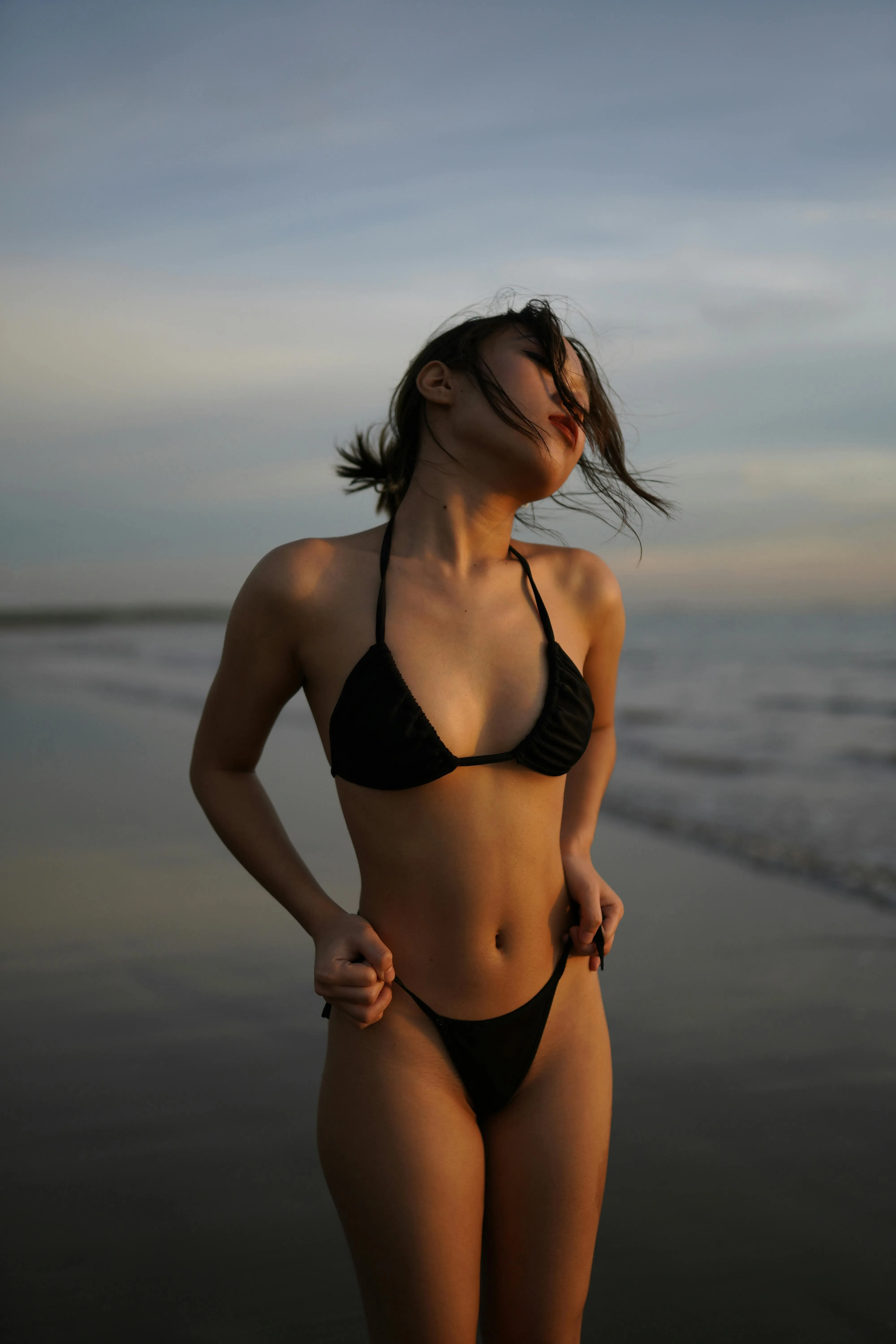 Woman Standing Calmly in Shallow Water at Golden Hour Image