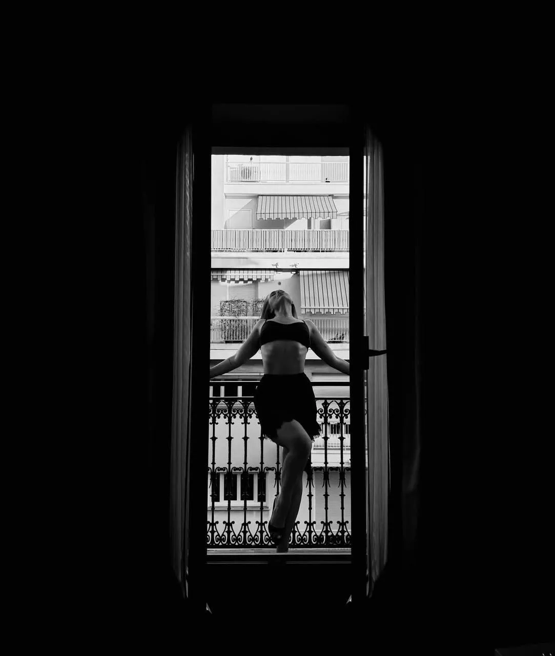 Woman standing in doorway with dramatic silhouette lighting