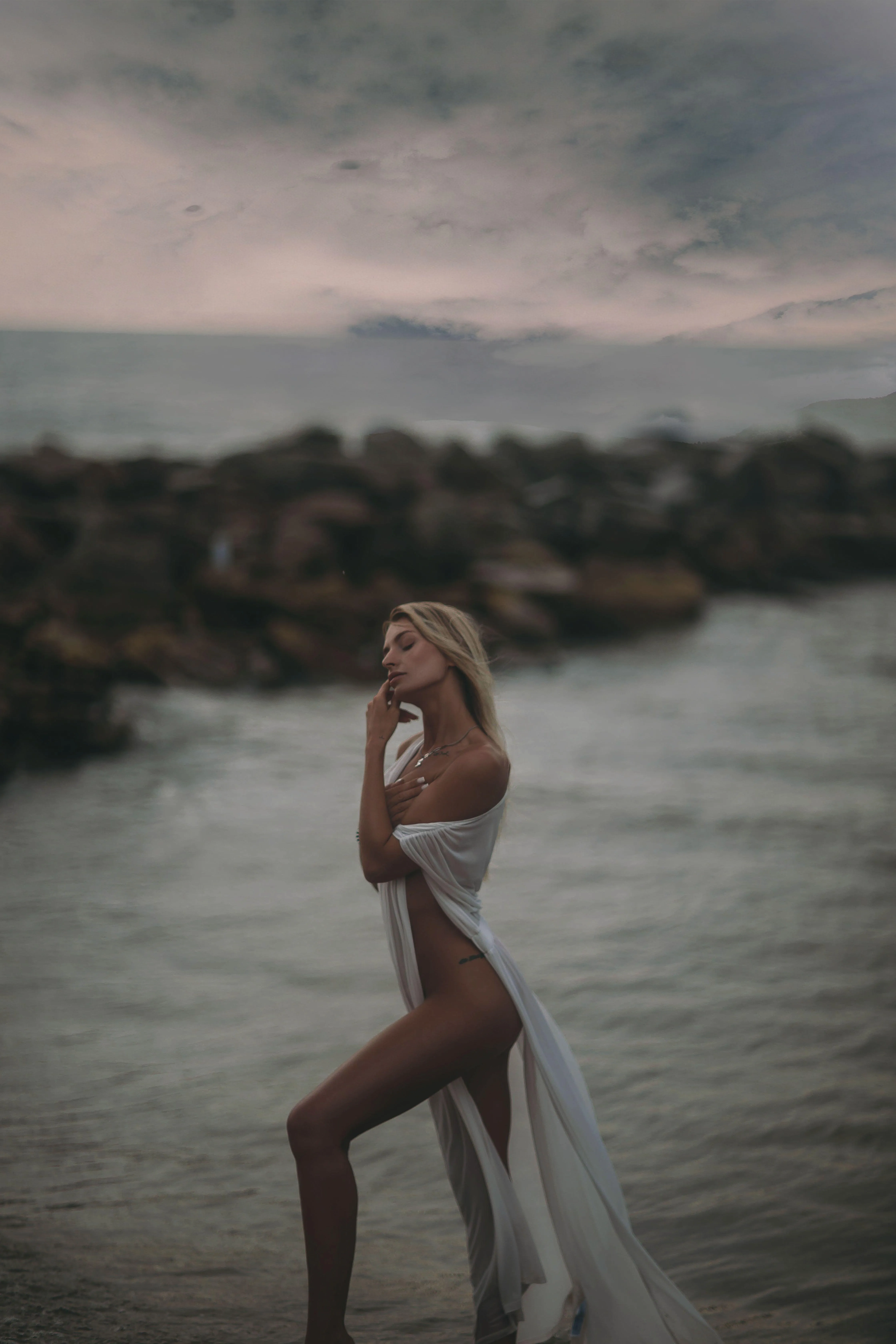 Woman Standing in Water with Misty Rocks in the Background