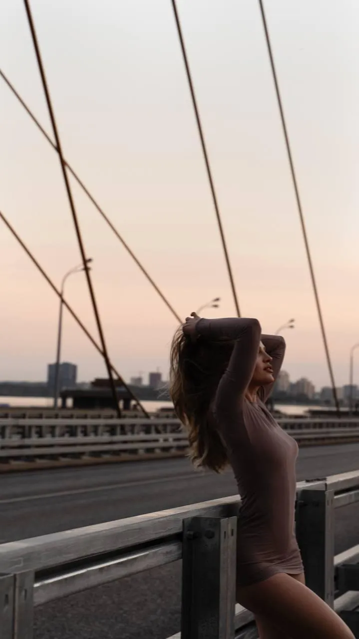 Woman standing on the bridge under the bright sky wallpaper