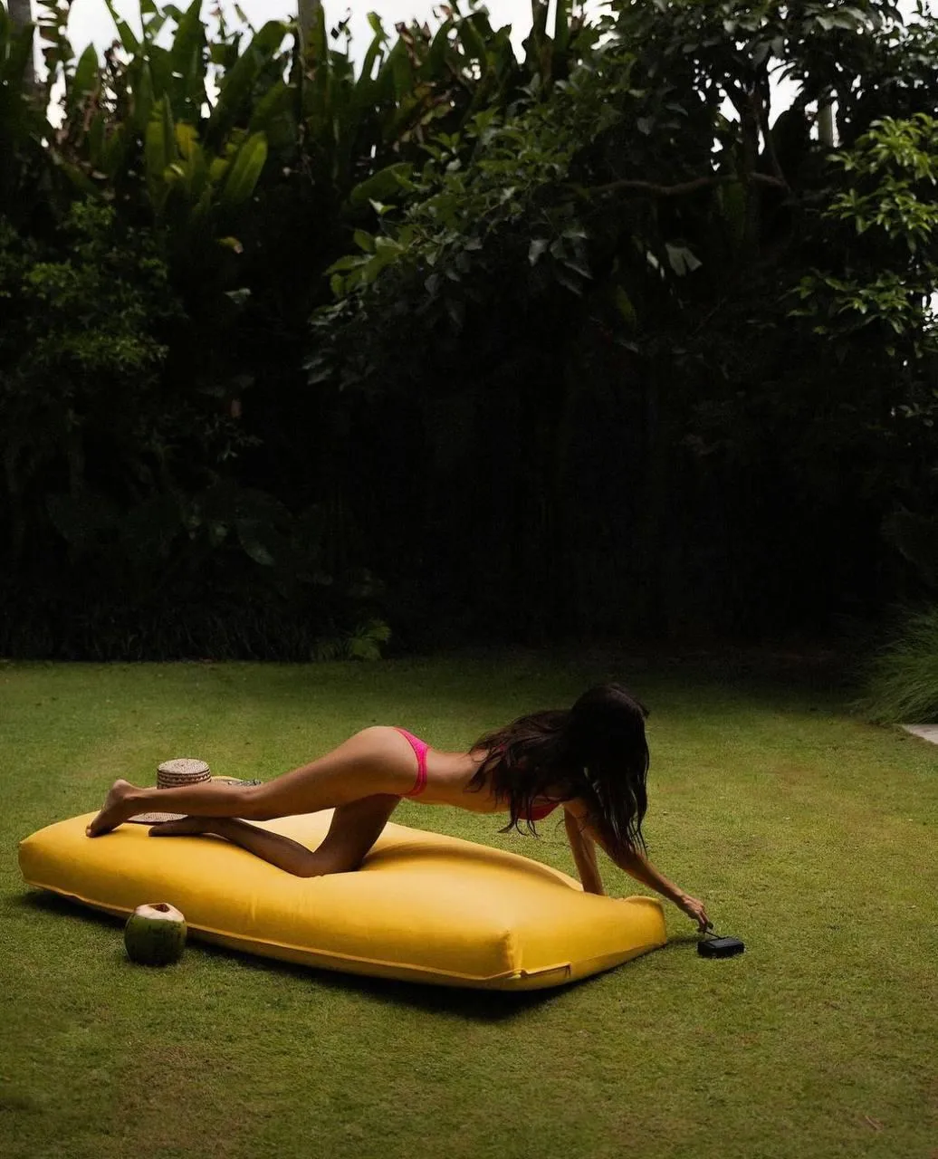 Woman Sunbathing on an Inflatable Float in a Green Lawn