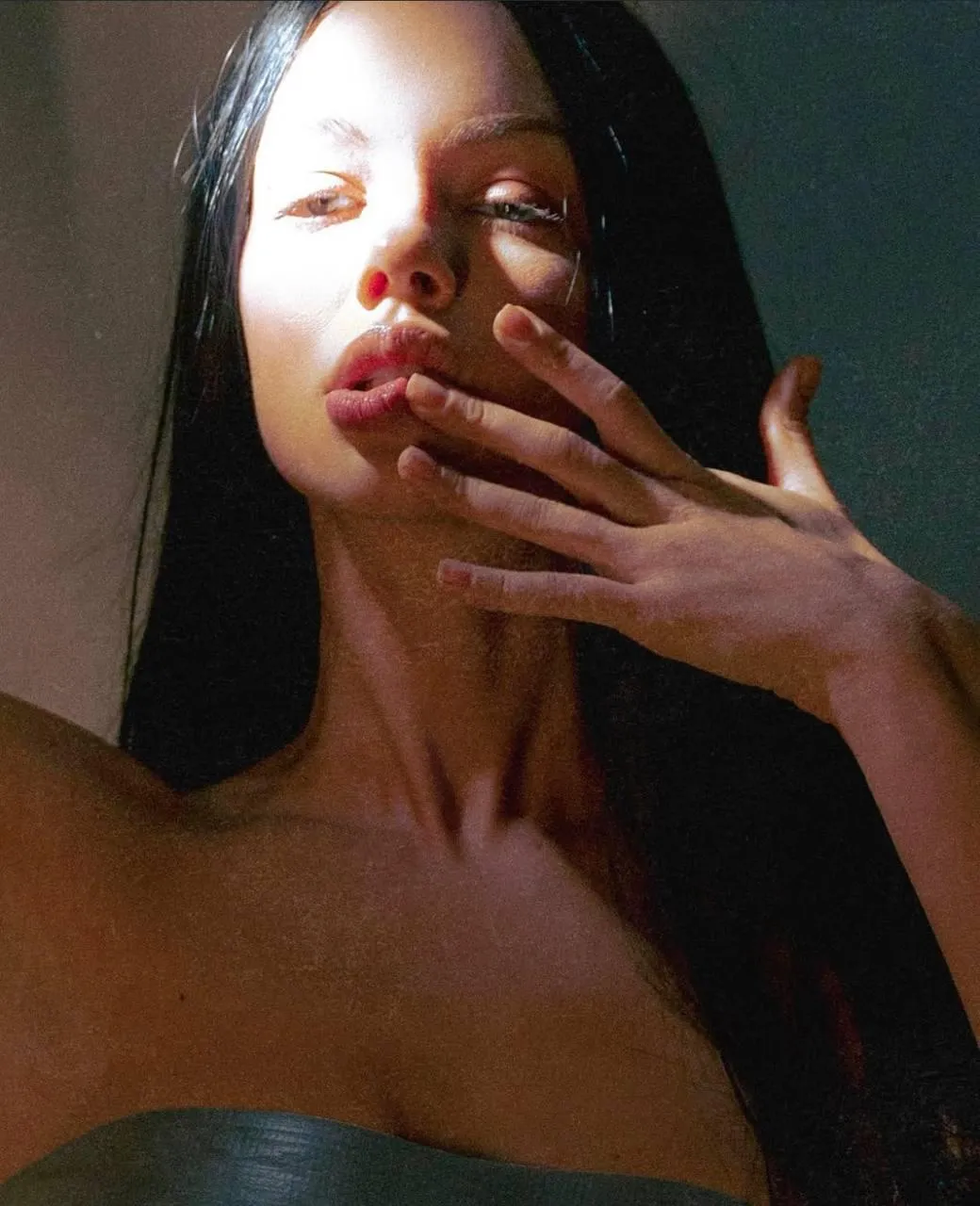 Woman Touching Face with Sunlight Casting Shadows Indoors