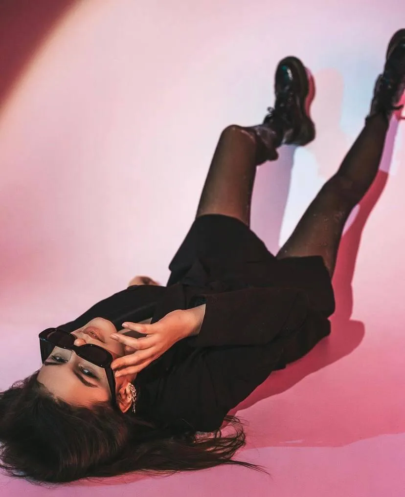 Woman wearing a black outfit and lying on the studio floor