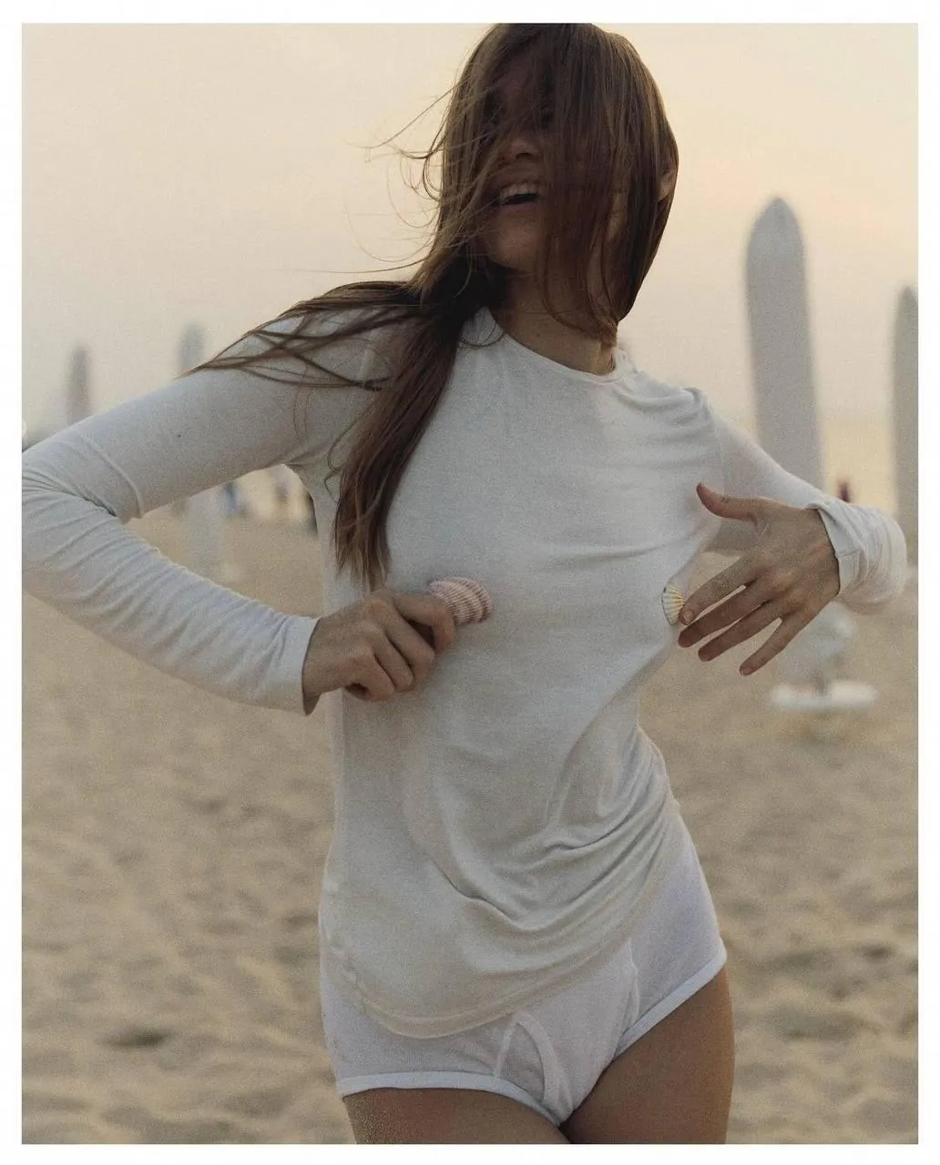 Woman Wearing a White Dress on a Sandy Beach in Soft Light