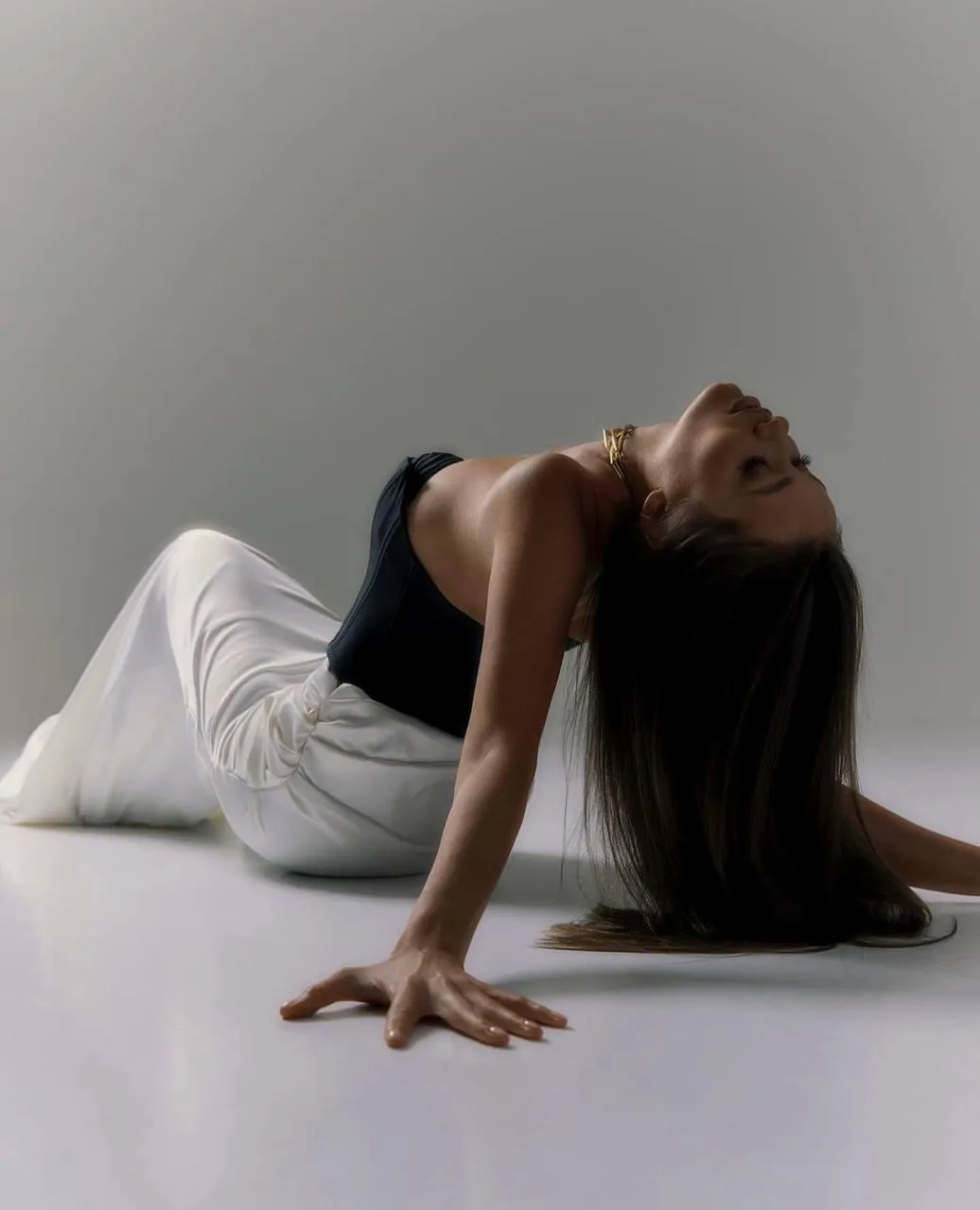 Woman with a black top and a white gown lying on the floor