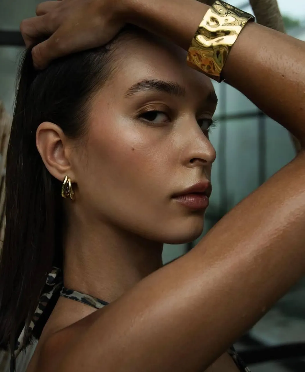Woman with bold makeup posing confidently near the window