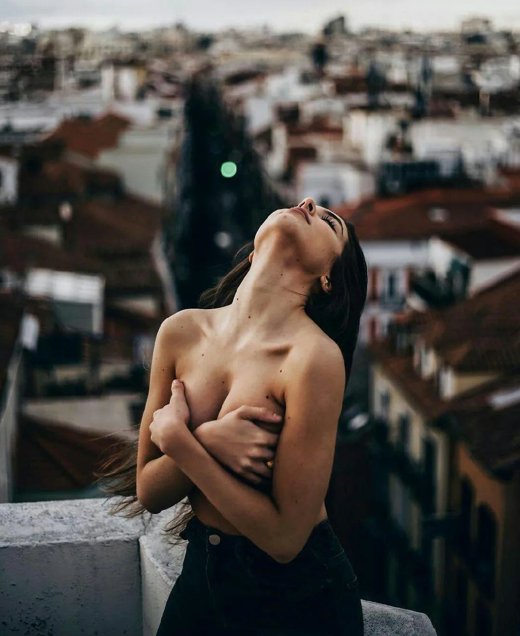 Woman with Short Hair Posing Nude on Rooftop with City View